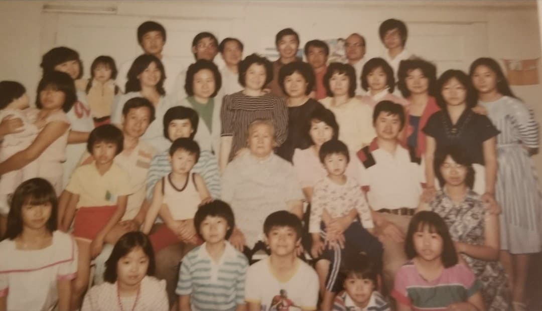 Extended Ye family portrait with Mike Ye’s grandmother seated in the center, surrounded by children and grandchildren, including Mike’s parents and Mike in a blue-striped shirt in front