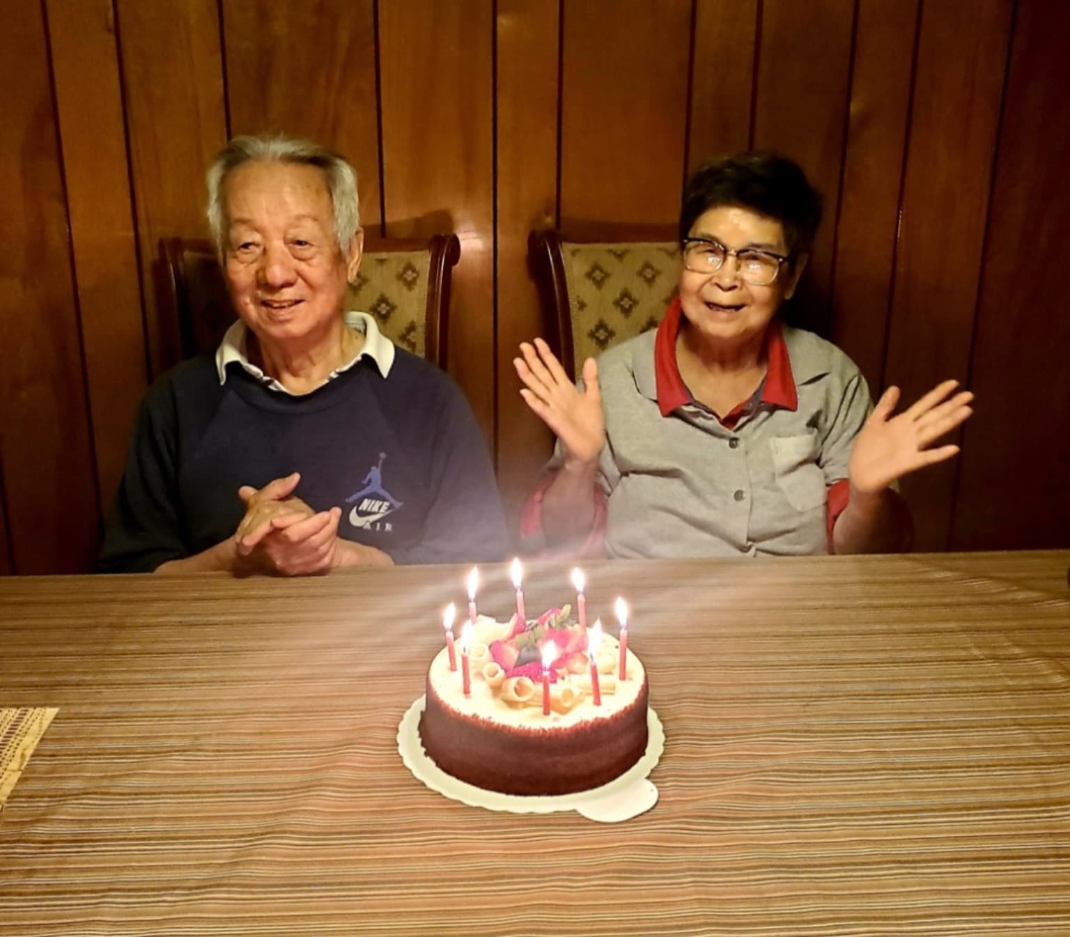 Ye Guozhi and his wife seated behind a birthday cake at his birthday celebration