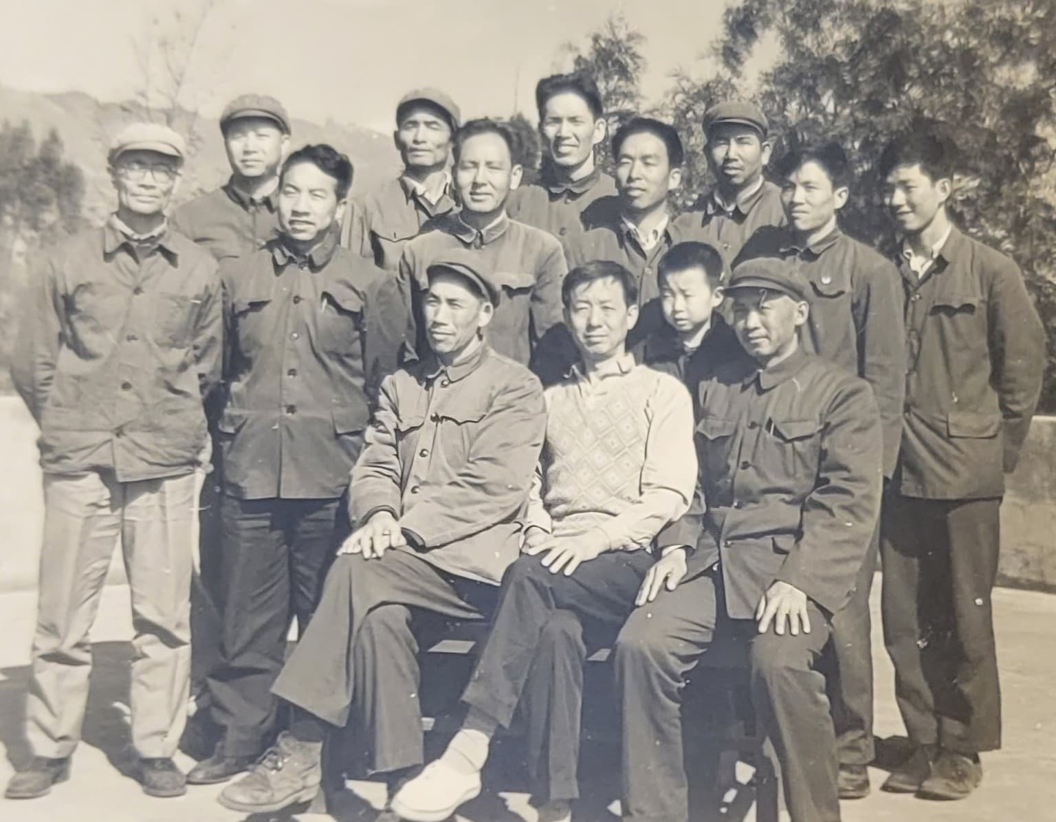 Ye Guozhi seated among his cement-factory coworkers with his young son Mike beside him